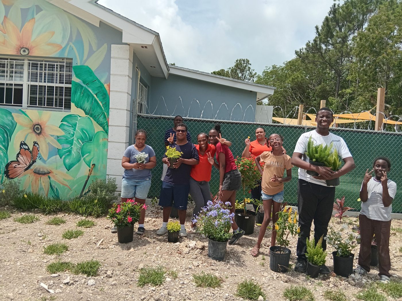 Students and staff gardening at the school mural