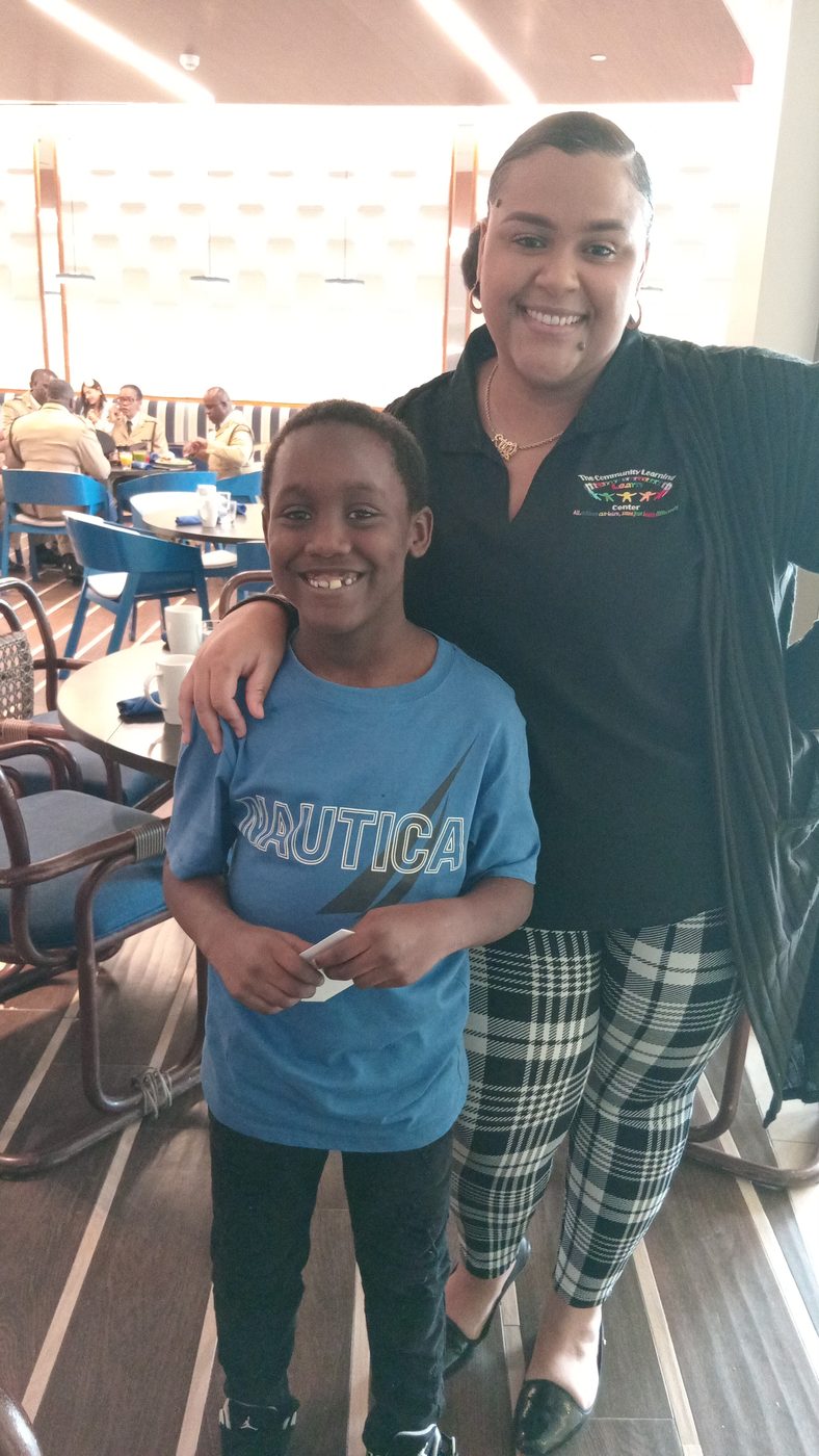 A student and staff member smiling together